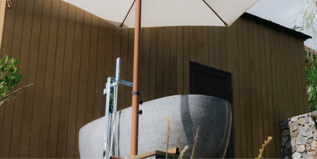 A serene bedroom with a soft bed, neutral-colored linens, and a large window showcasing the view of the surrounding nature, offering a calming and refreshing atmosphere for guests.
