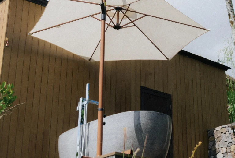 A luxurious outdoor bathtub with an umbrella, offering a peaceful soak while taking in the panoramic view of nature.