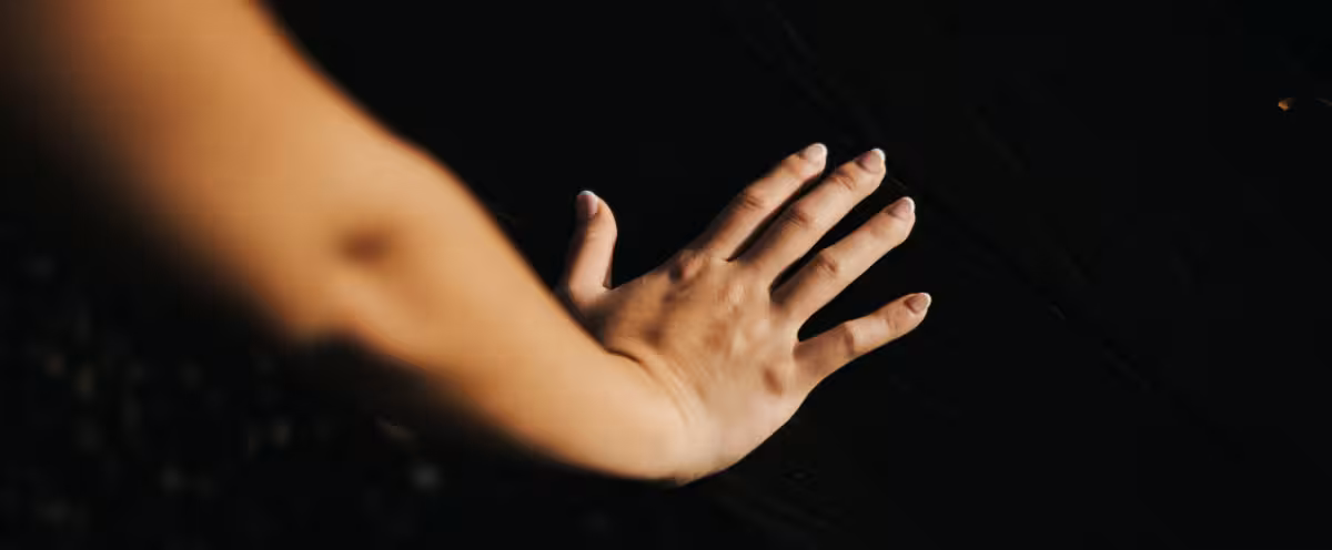 A hand gently touching the surface of nature at Rimbun Farm, connecting with the land's natural beauty