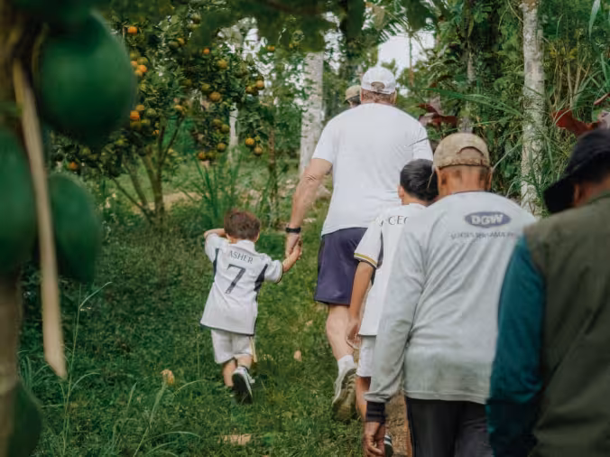 Two hikers exploring the lush trails in the forest at Rimbun Farm, experiencing the beauty of nature.